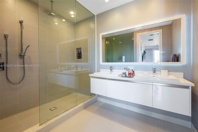 full bathroom featuring double vanity, a sink, and a walk in shower