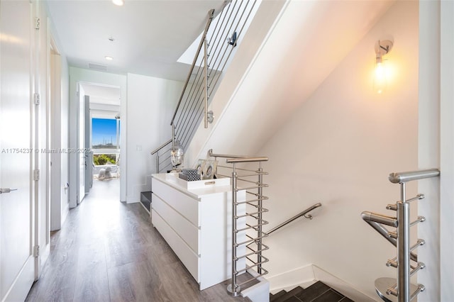 stairs featuring baseboards, visible vents, wood finished floors, and recessed lighting