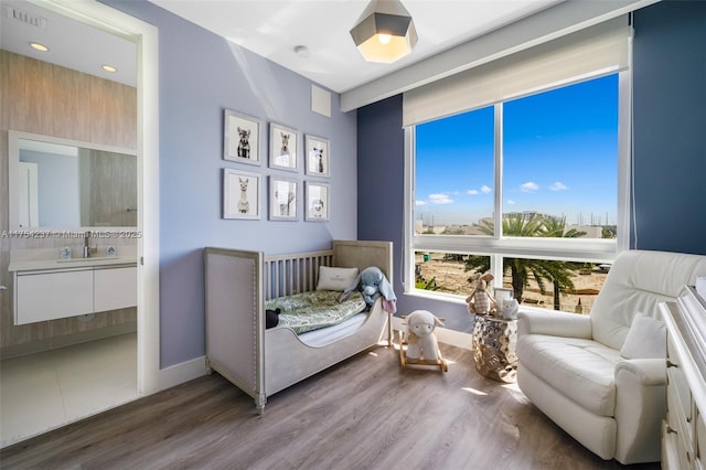 bedroom featuring wood finished floors, visible vents, and baseboards