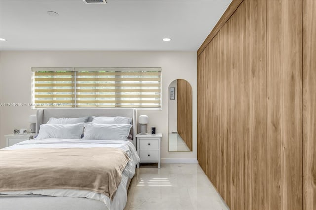 bedroom with recessed lighting, arched walkways, multiple windows, and baseboards