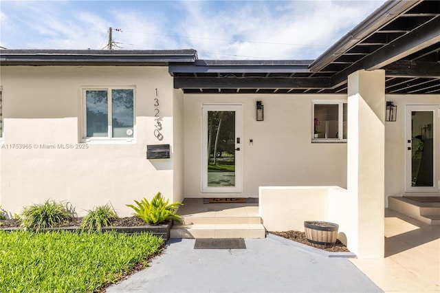doorway to property featuring stucco siding