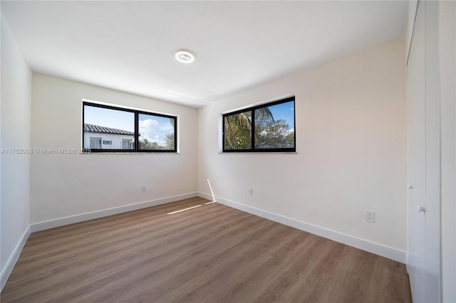 unfurnished room featuring wood finished floors and baseboards