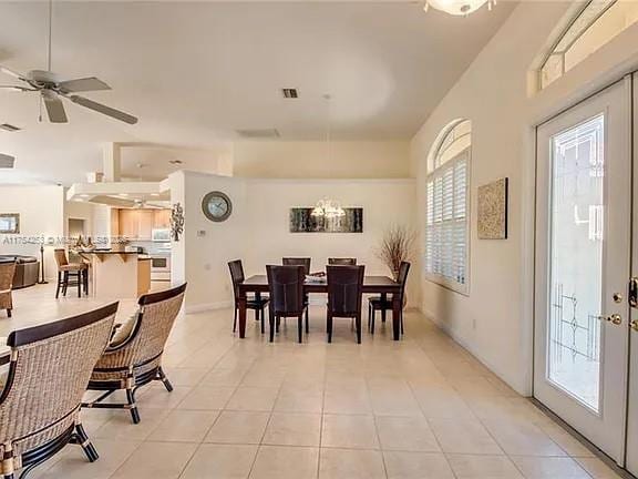 dining area with light tile patterned floors, visible vents, a ceiling fan, and french doors