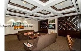 carpeted cinema with beamed ceiling and coffered ceiling