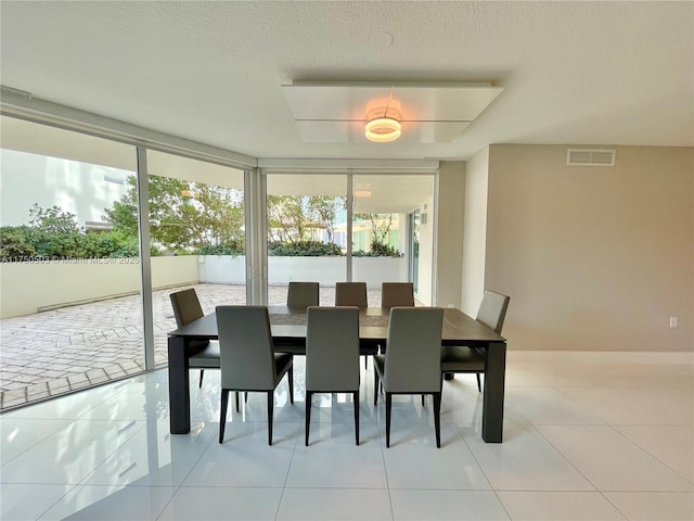 dining area with visible vents, expansive windows, a textured ceiling, and tile patterned flooring