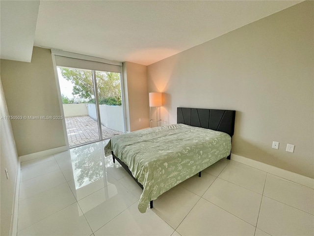 tiled bedroom with baseboards and access to outside