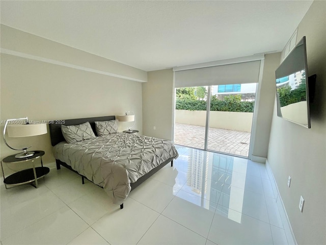 tiled bedroom featuring access to exterior, floor to ceiling windows, and baseboards