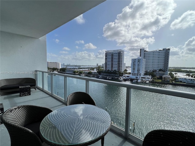 balcony featuring a water view and a city view