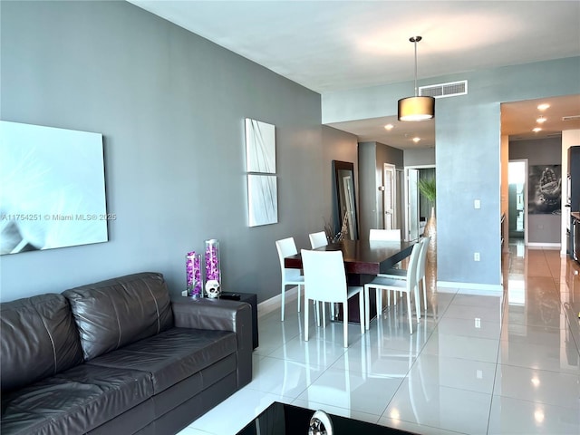 living area with light tile patterned floors, visible vents, and baseboards