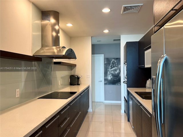 kitchen featuring island exhaust hood, stainless steel refrigerator with ice dispenser, tasteful backsplash, visible vents, and modern cabinets