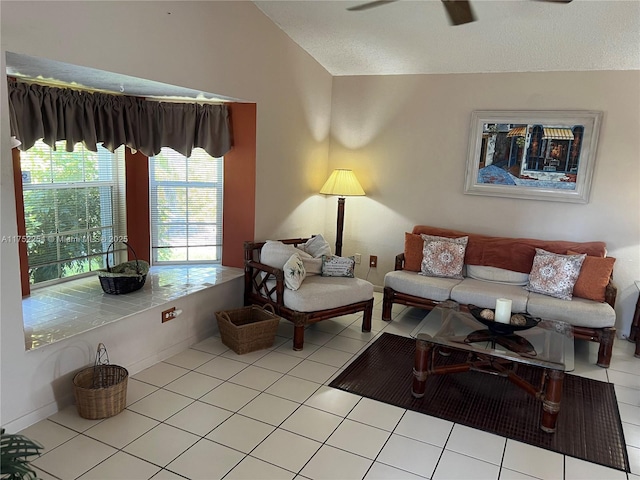 living room featuring a ceiling fan, vaulted ceiling, baseboards, and light tile patterned floors