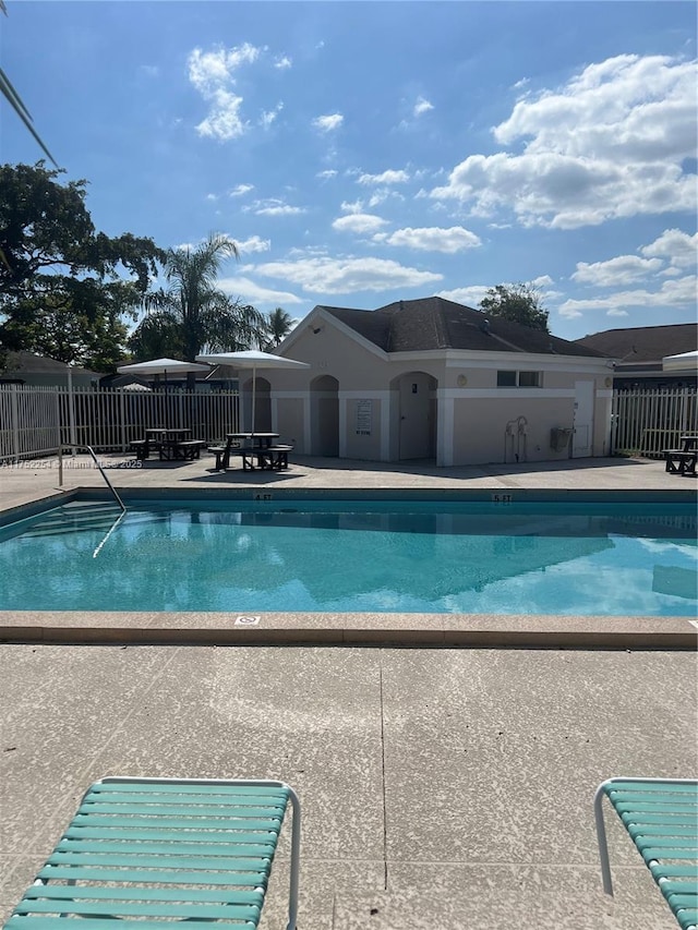 community pool with fence and a patio