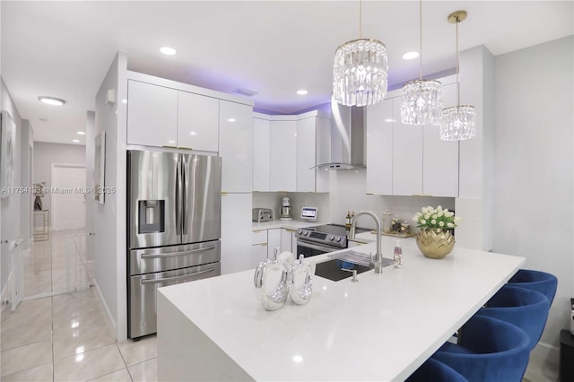 kitchen featuring stainless steel appliances, a peninsula, white cabinetry, wall chimney exhaust hood, and modern cabinets