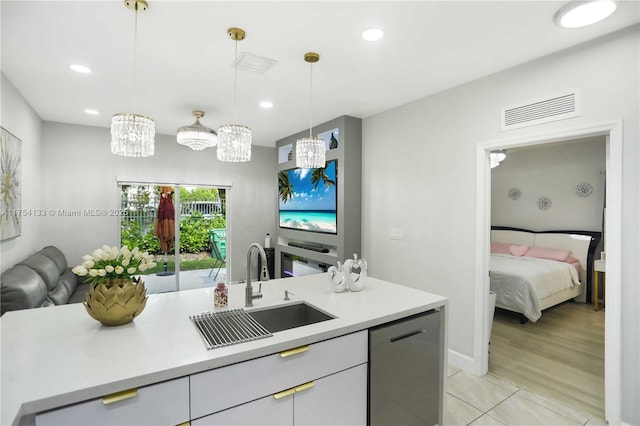 kitchen featuring a sink, visible vents, open floor plan, light countertops, and stainless steel dishwasher