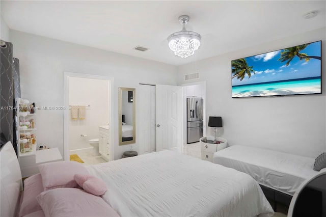 bedroom with a chandelier, visible vents, stainless steel refrigerator with ice dispenser, and ensuite bathroom