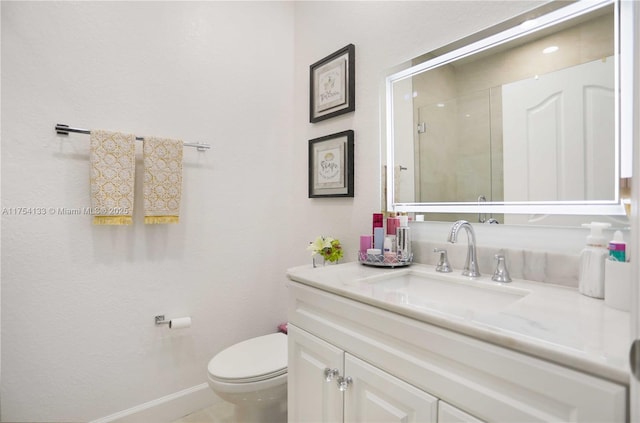 full bath featuring toilet, a shower stall, vanity, and baseboards