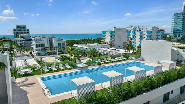 view of swimming pool featuring a city view and a water view