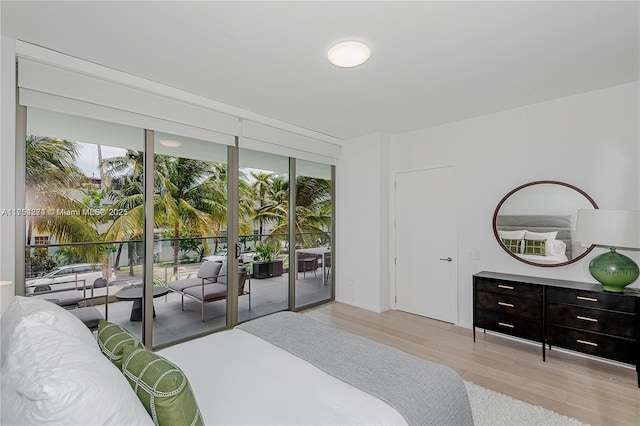 bedroom featuring expansive windows, access to outside, and light wood-style flooring