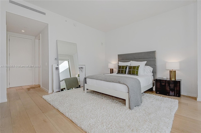 bedroom with visible vents and light wood-style flooring