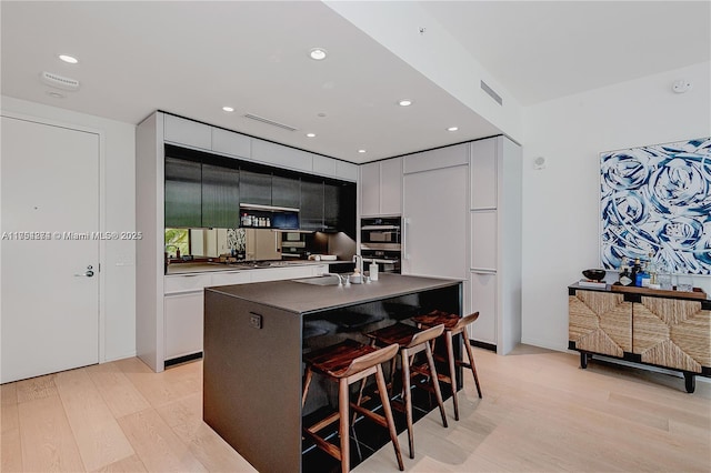 kitchen with light wood-type flooring, visible vents, and modern cabinets