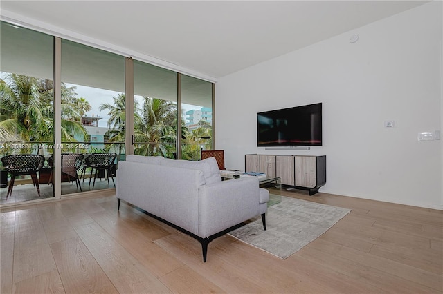 living area featuring expansive windows, wood finished floors, and baseboards