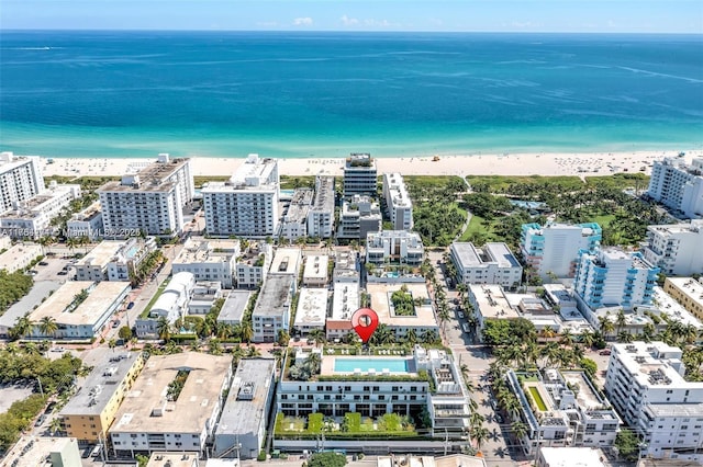 bird's eye view with a water view, a view of the beach, and a city view