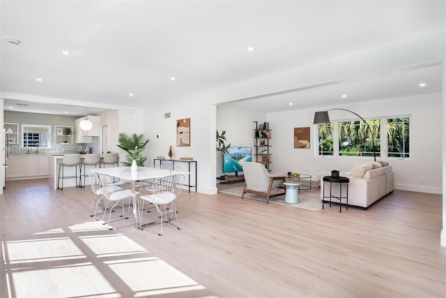 dining space featuring recessed lighting, light wood-type flooring, and baseboards