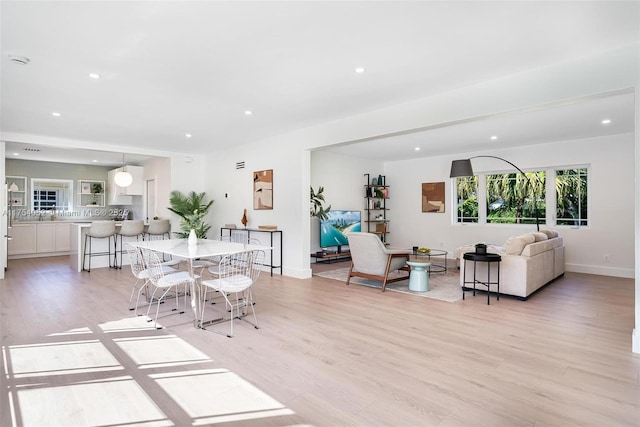 dining room with recessed lighting, baseboards, and light wood-type flooring