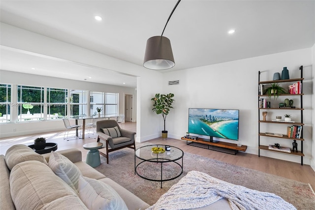 living area with recessed lighting, baseboards, and wood finished floors