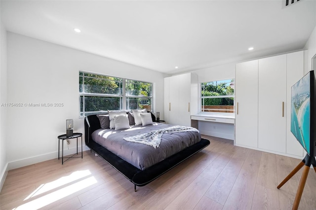 bedroom with baseboards, visible vents, recessed lighting, and light wood-style floors
