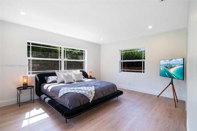 bedroom with recessed lighting, multiple windows, baseboards, and wood finished floors