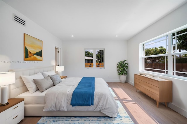 bedroom with light wood-style floors, multiple windows, and recessed lighting