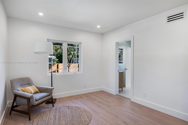 living area with baseboards, visible vents, wood finished floors, and recessed lighting