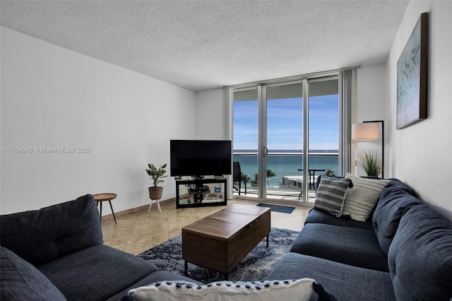 tiled living room with a wall of windows, a textured ceiling, and baseboards