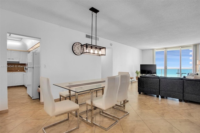 dining room featuring light tile patterned floors, visible vents, and a textured ceiling