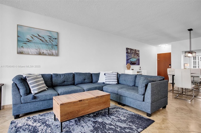 living area with a textured ceiling and light tile patterned floors