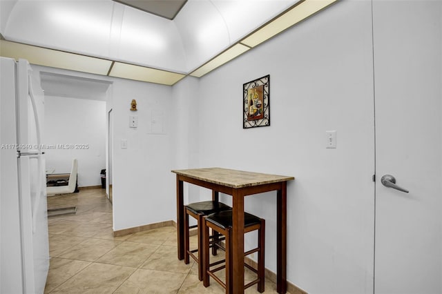 hallway featuring light tile patterned floors and baseboards