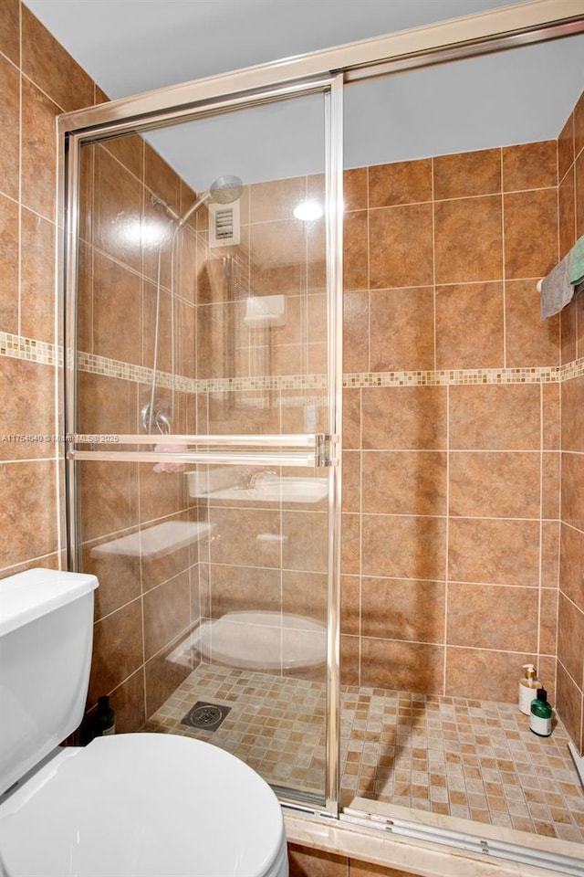 full bath with a shower stall and toilet