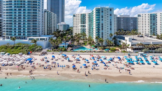 birds eye view of property with a water view, a view of the beach, and a city view