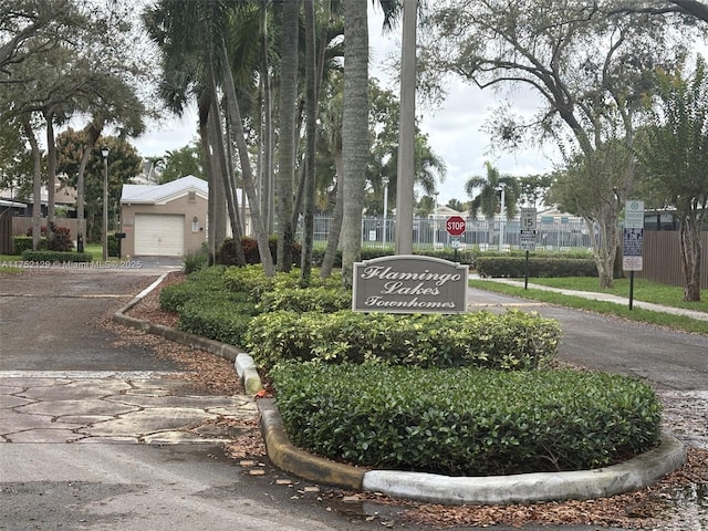 community sign featuring driveway and fence