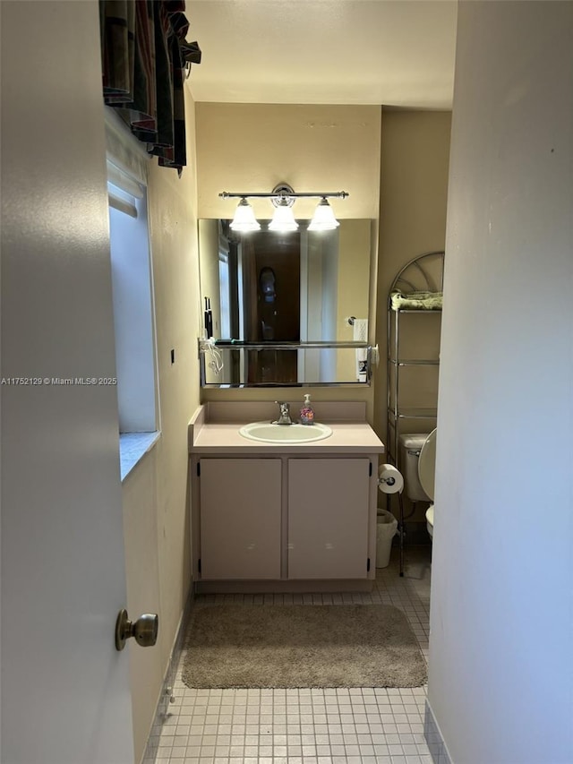 bathroom with toilet, tile patterned floors, and vanity