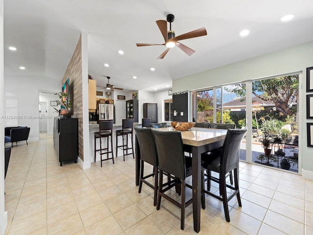 dining room featuring recessed lighting, baseboards, vaulted ceiling, and light tile patterned flooring