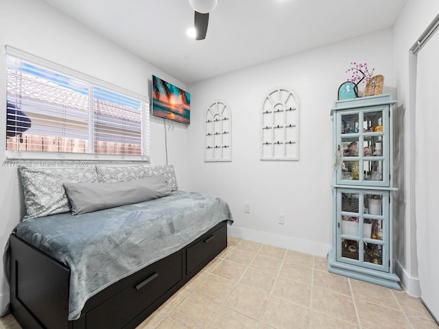 bedroom featuring a ceiling fan, baseboards, and light tile patterned floors