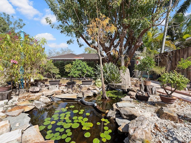 view of yard with a garden pond and fence