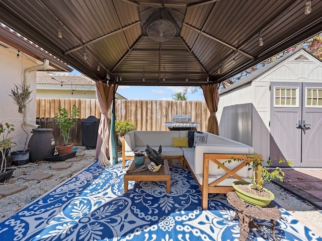 view of patio featuring an outbuilding, fence, a gazebo, and a storage shed