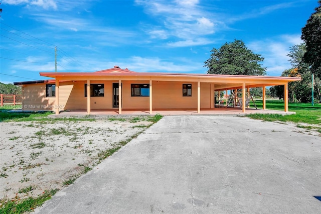 view of front of house featuring an attached carport and driveway