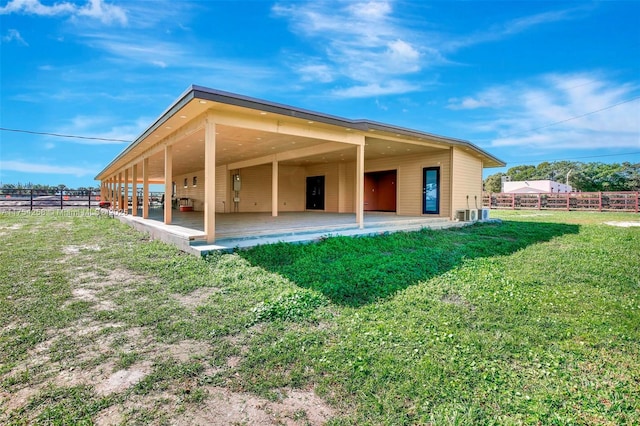 rear view of property featuring fence and a lawn