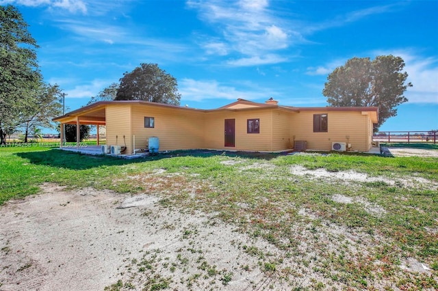 back of property featuring fence and a lawn