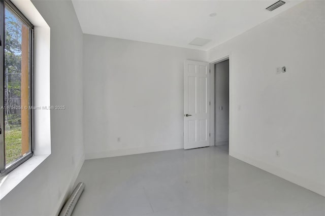 unfurnished room featuring baseboards, visible vents, and a healthy amount of sunlight