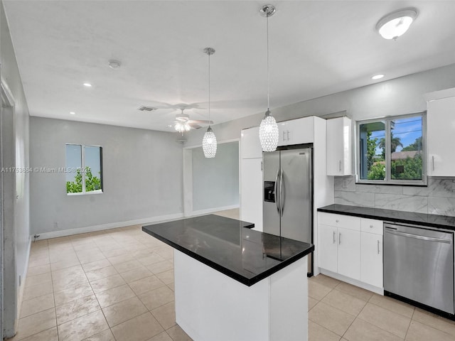 kitchen with white cabinets, backsplash, decorative light fixtures, and appliances with stainless steel finishes